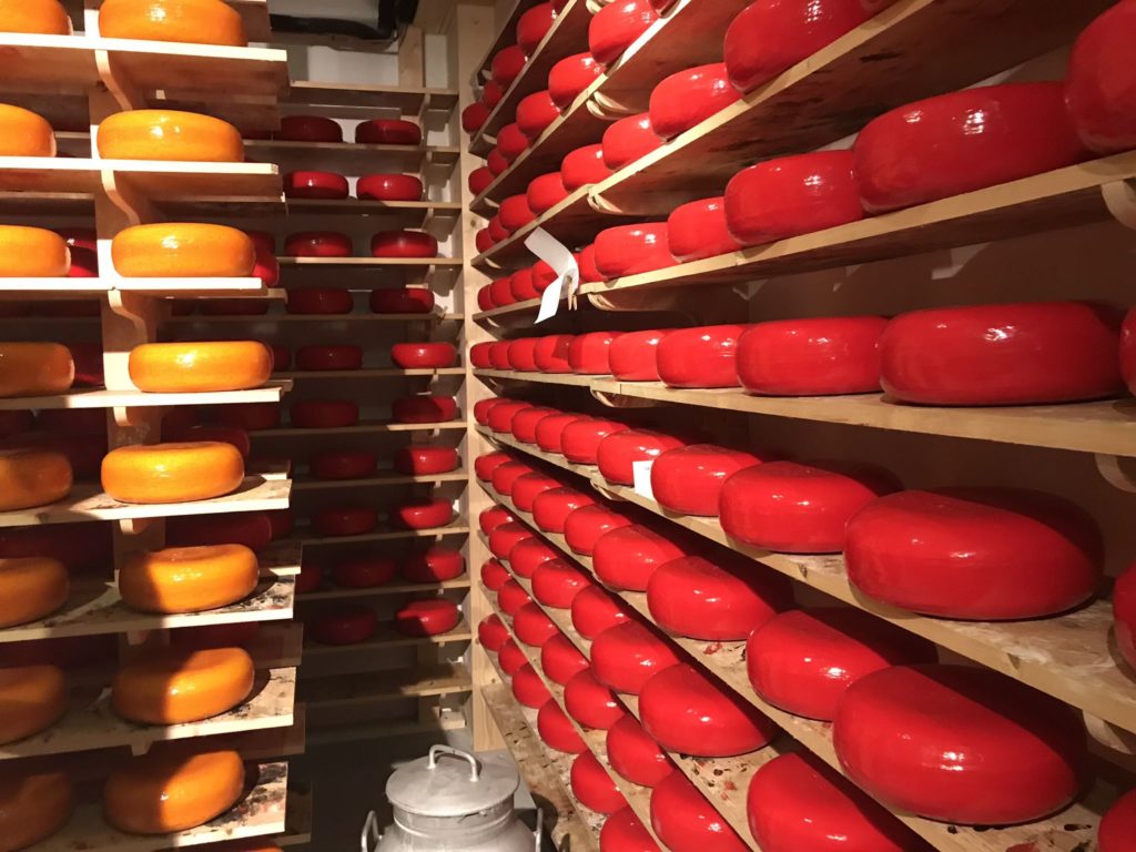 shelves with red and yellow cheeses