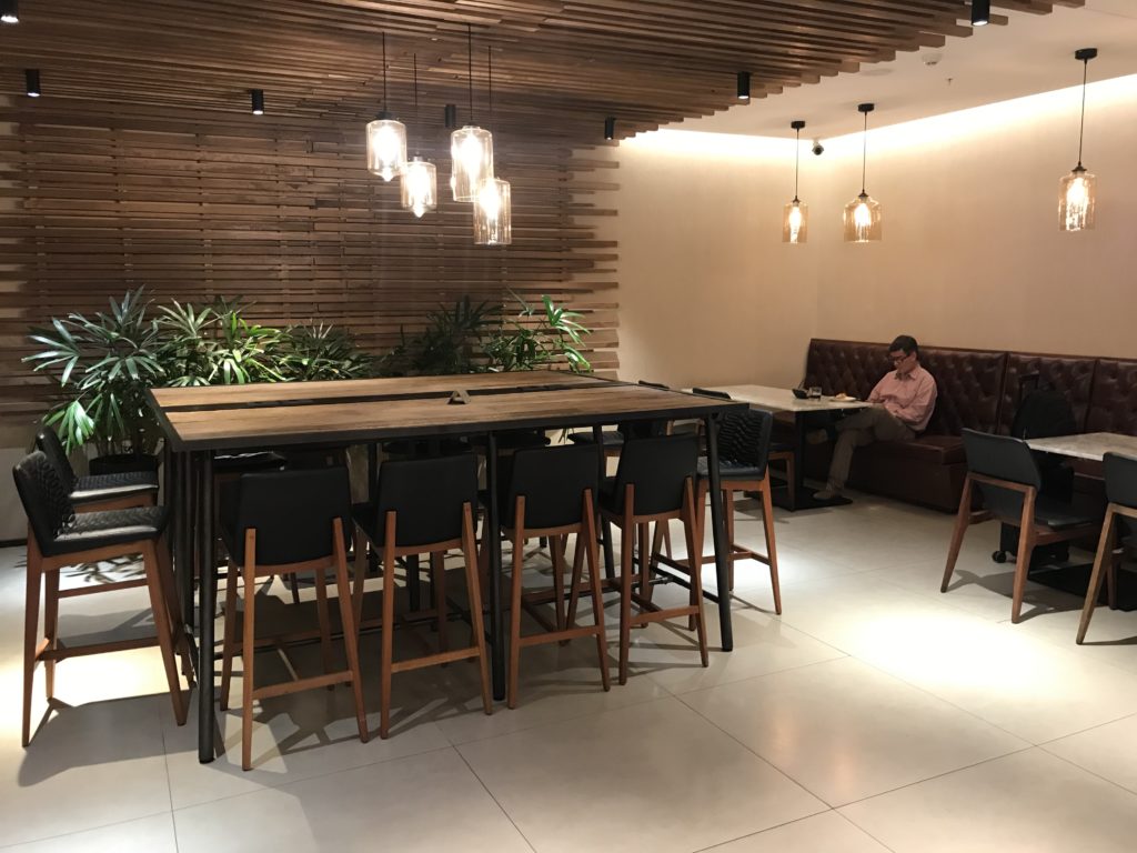 a man sitting at a table in a room with chairs and a table