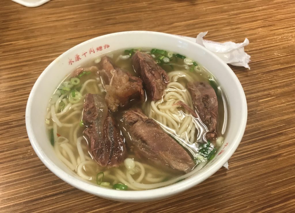a bowl of soup with meat and noodles