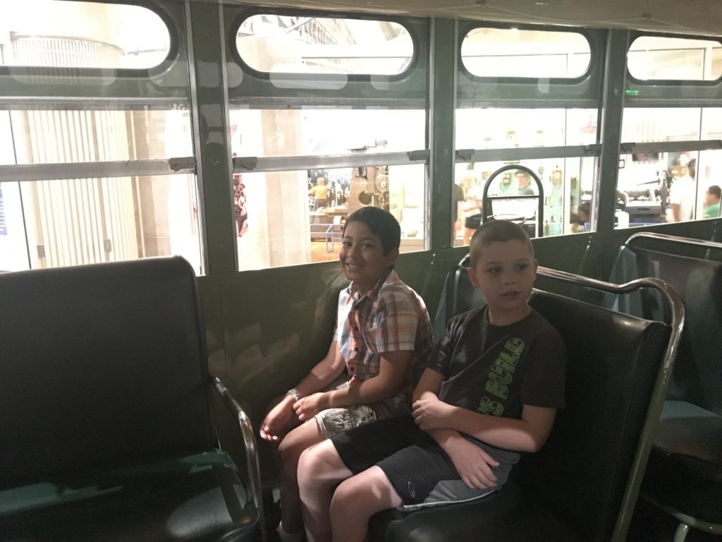 two boys sitting on a bus
