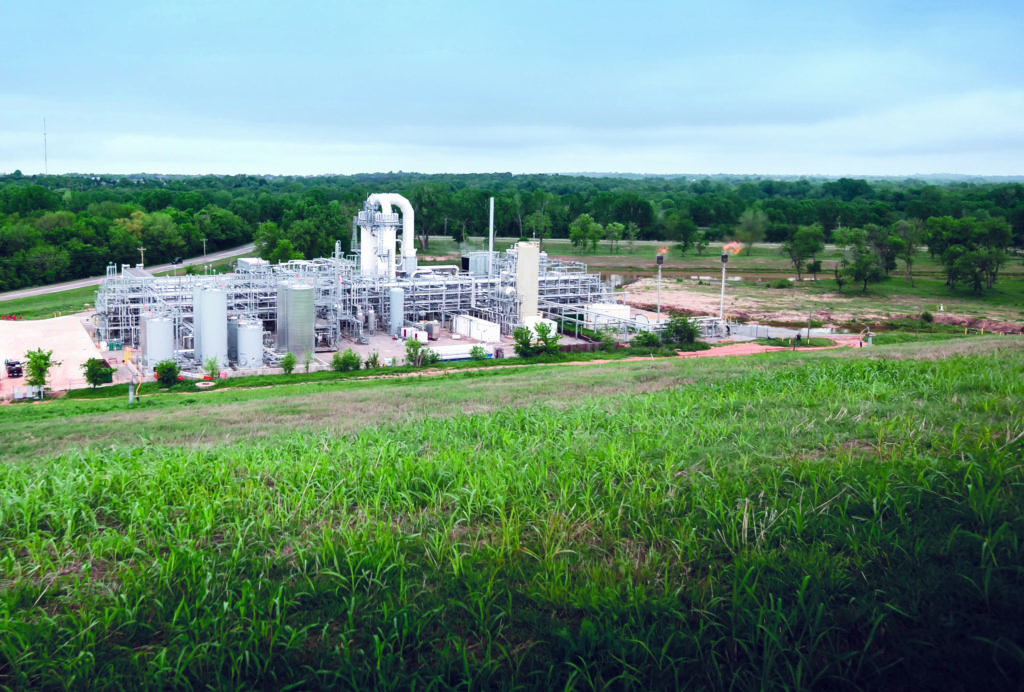a large factory with a field of grass