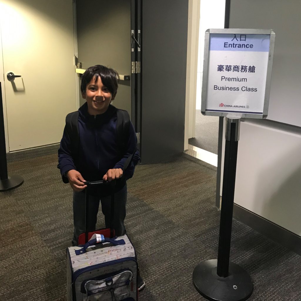 a boy standing in a hallway with luggage