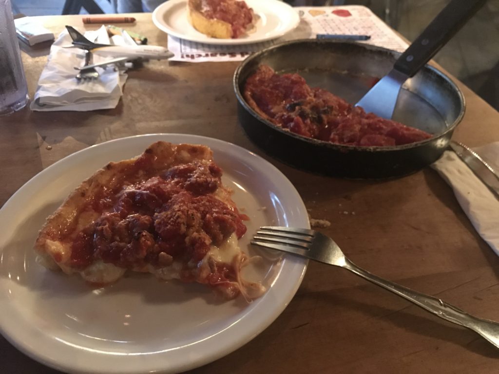 a plate of pizza and a pan of food on a table