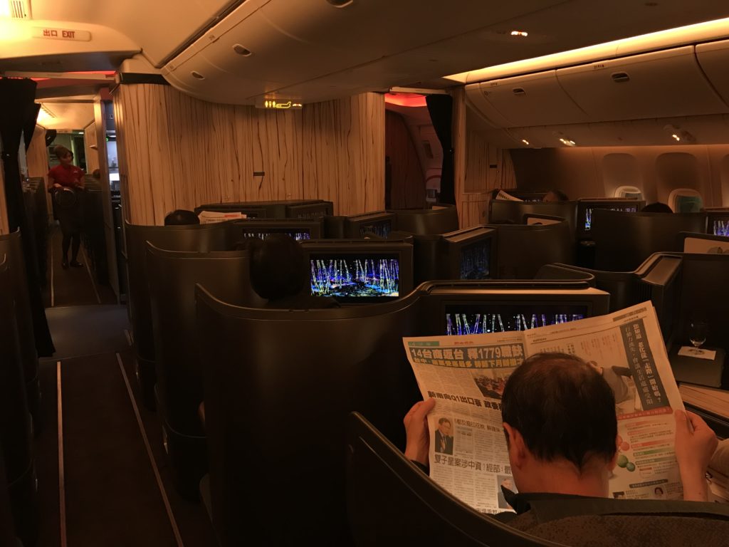 a man reading a newspaper in an airplane