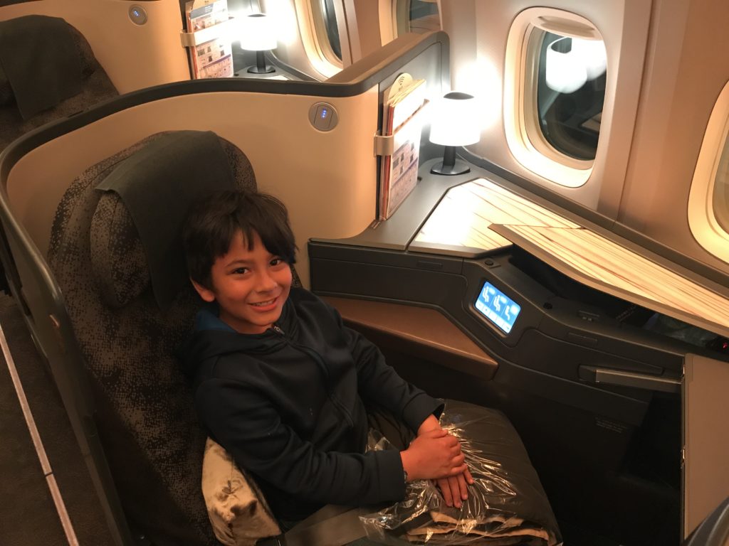 a boy sitting in a chair in an airplane
