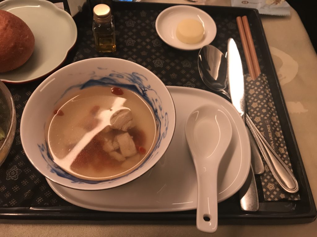 a bowl of soup and spoon on a tray