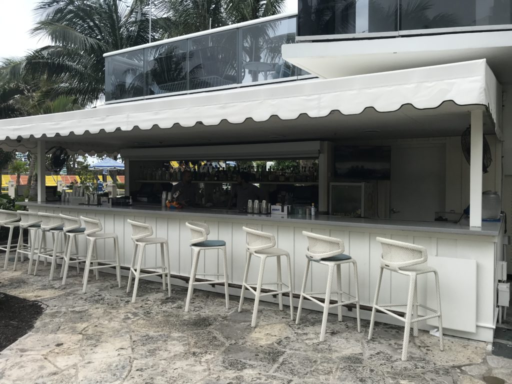 a white bar with chairs outside