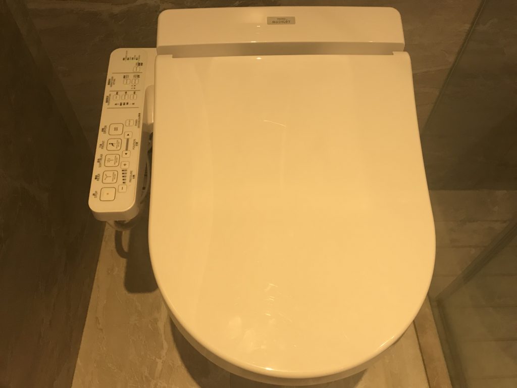 a white toilet with buttons