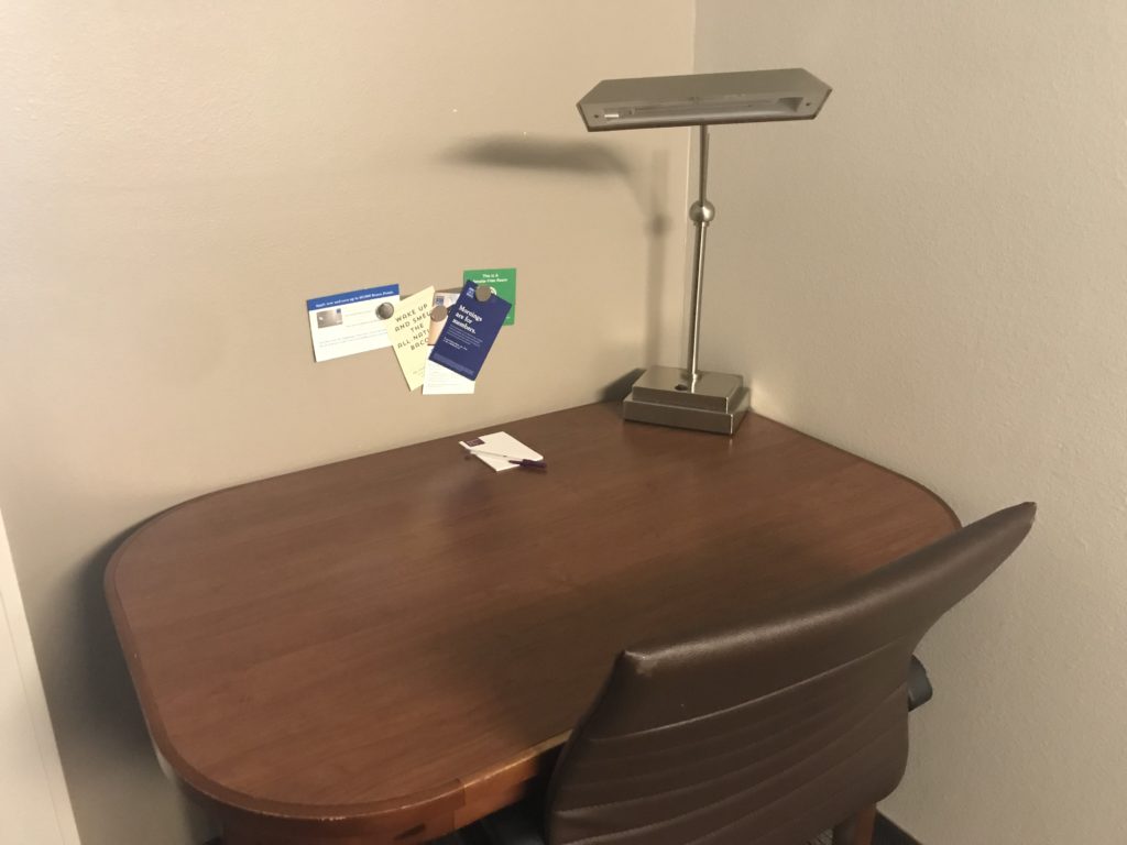a desk with a lamp and a chair