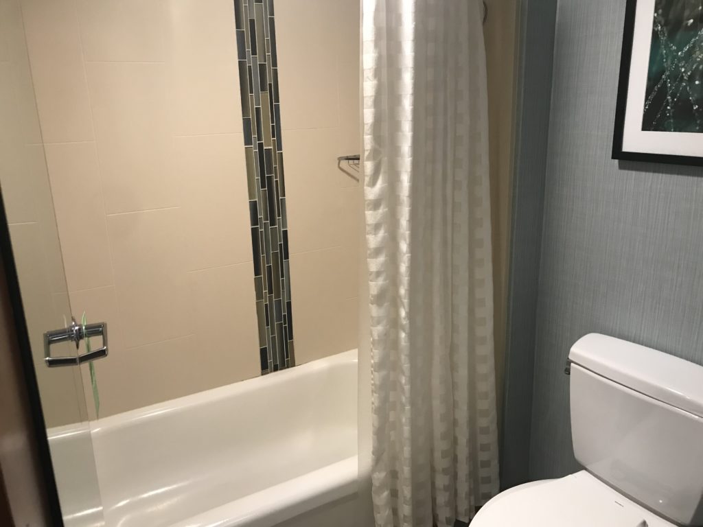 a bathroom with a white bathtub and shower curtain