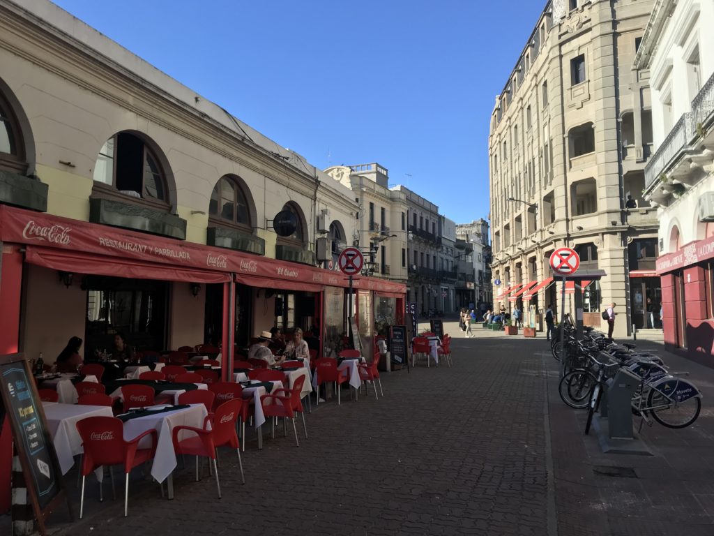 a street with tables and chairs in front of buildings
