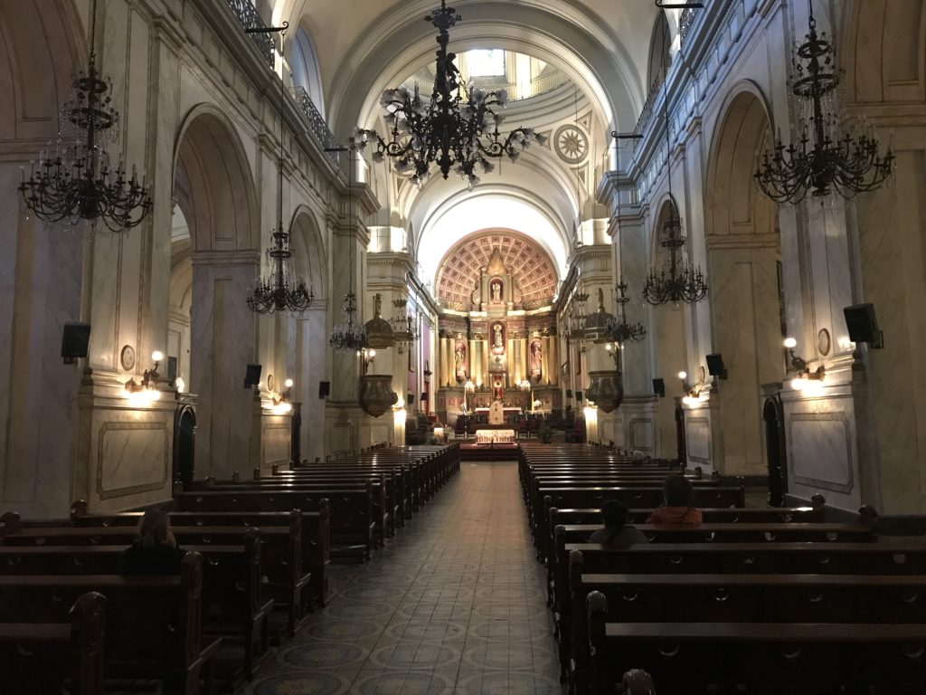 a church with many pews and chandeliers