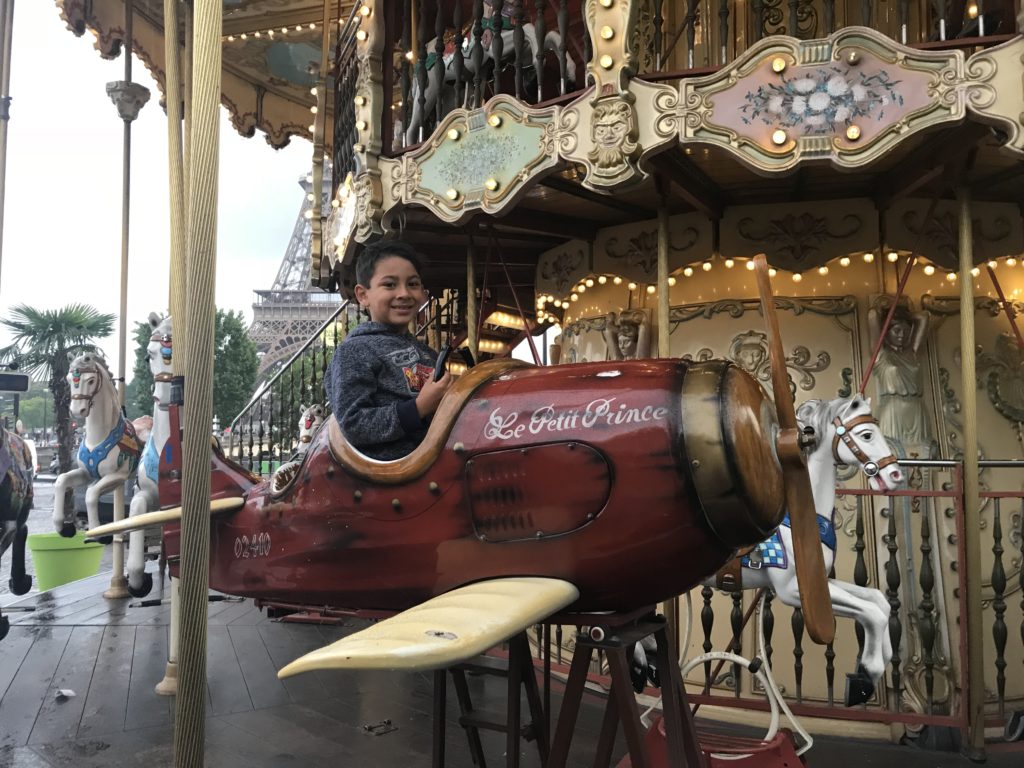 a boy in a plane on a carousel