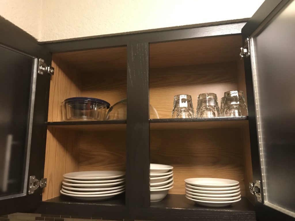 a cabinet with plates and glasses on it