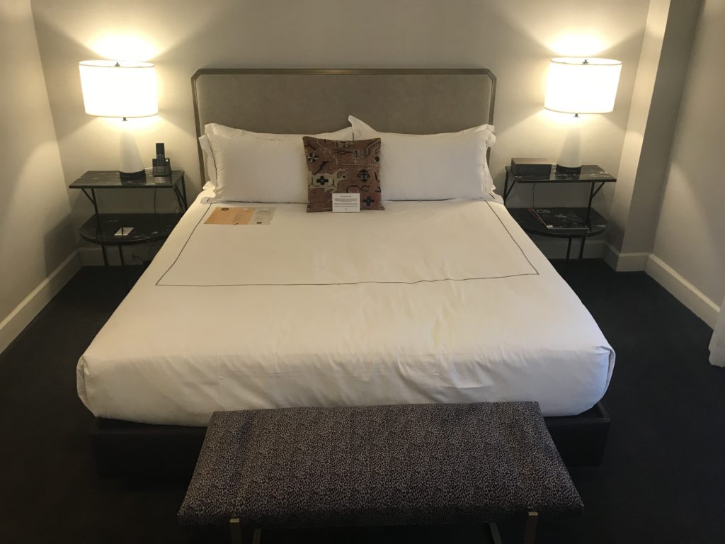 a bed with a white bedding and two lamps