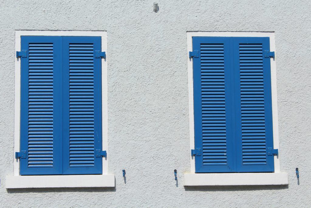 a pair of blue shutters on a white wall