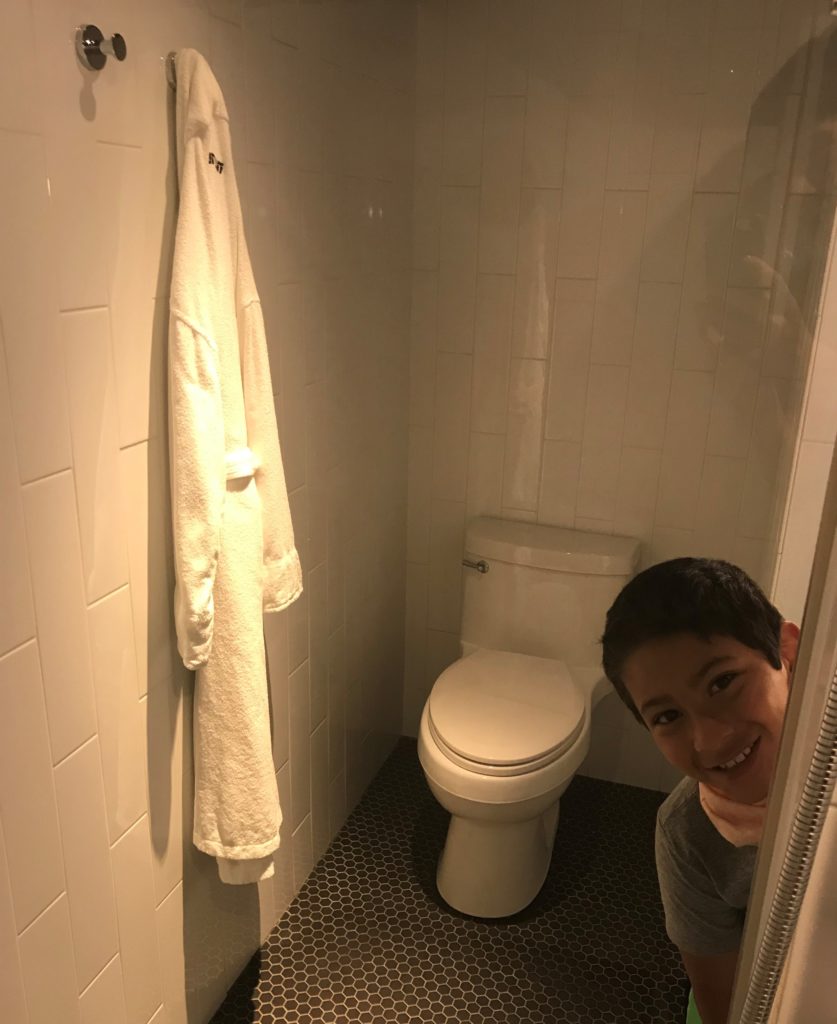 a boy taking a selfie in a bathroom
