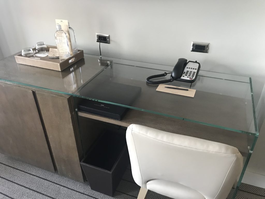 a desk with a phone and a chair