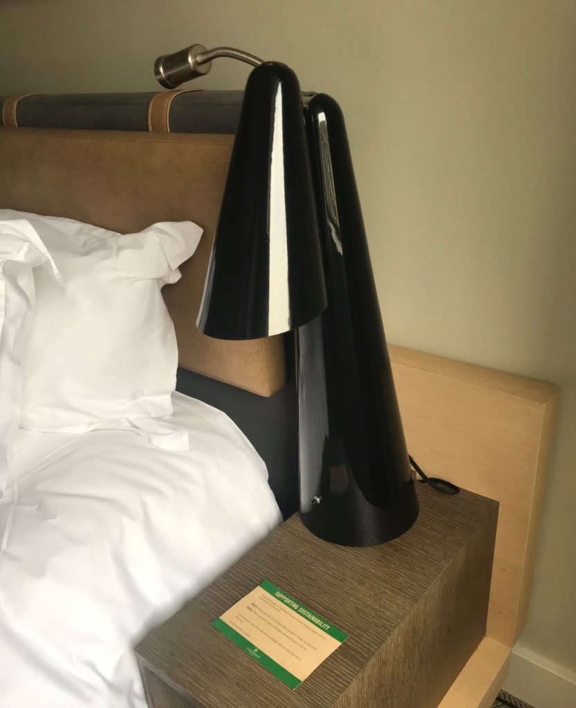 a lamp on a nightstand next to a bed