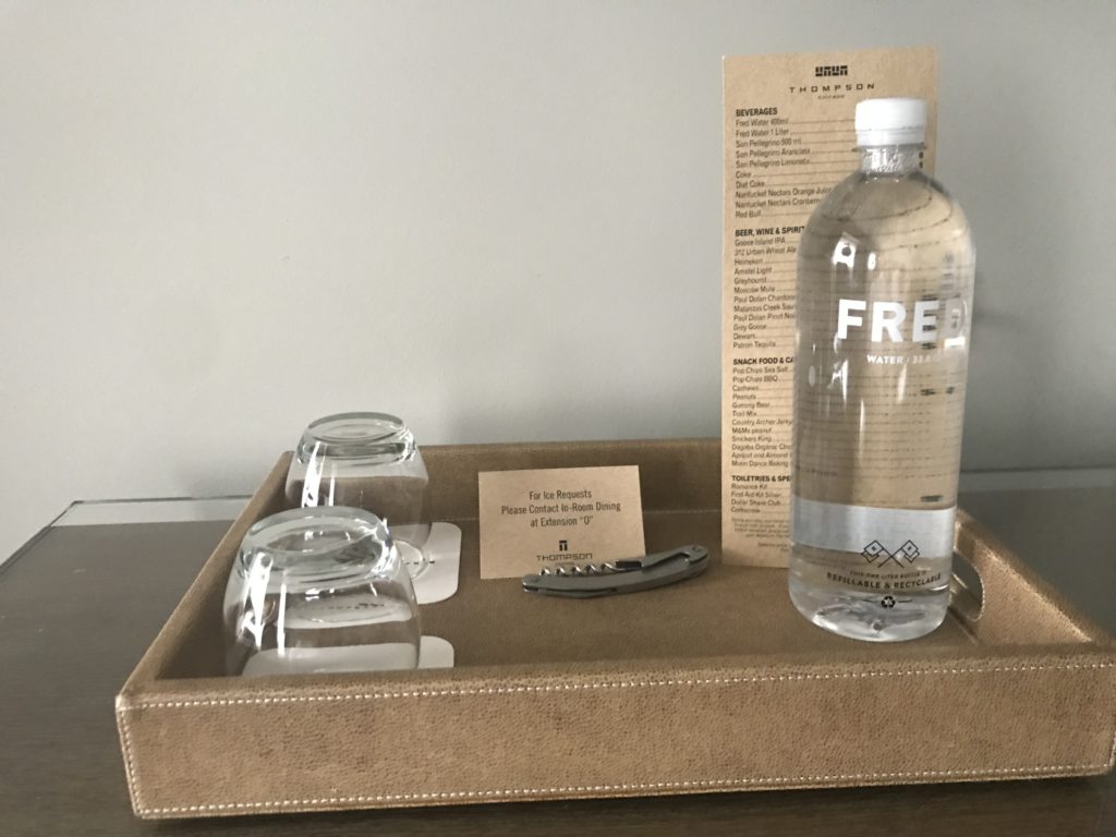 a tray with a bottle and glasses on it