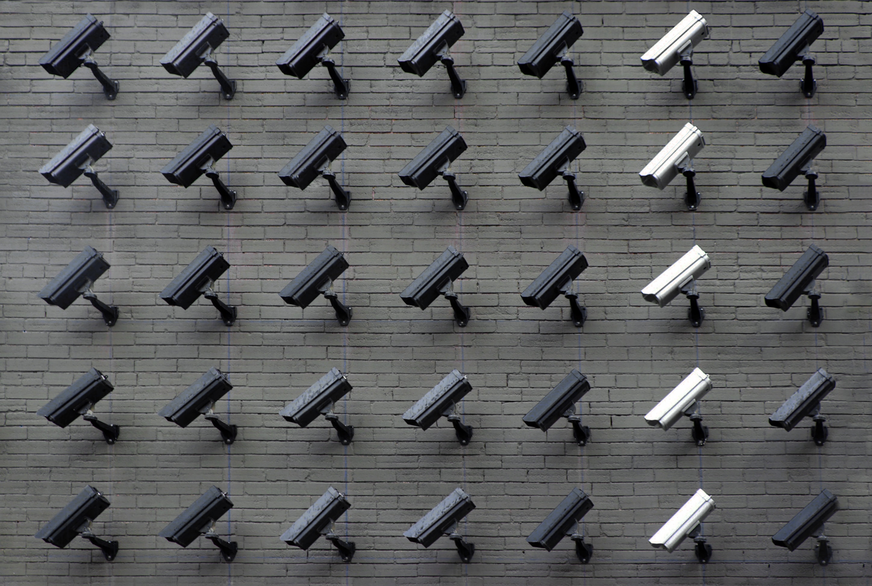 a group of cameras on a brick wall