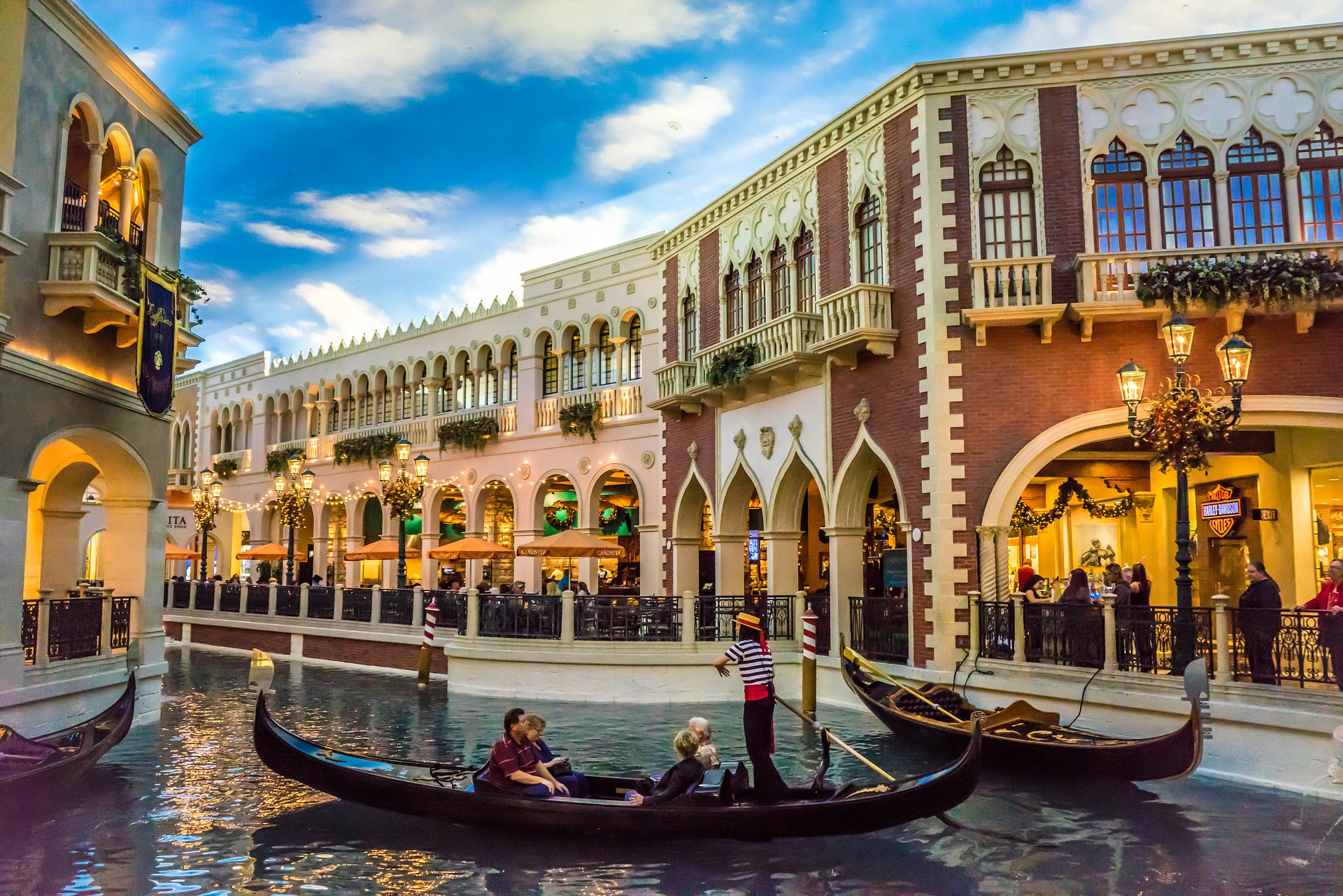 a gondola on a canal with people in it with The Venetian Las Vegas in the background