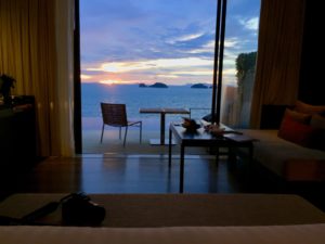 a room with a table and chairs and a view of the ocean