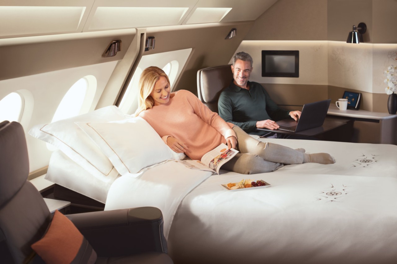 a man and woman on a bed in an airplane