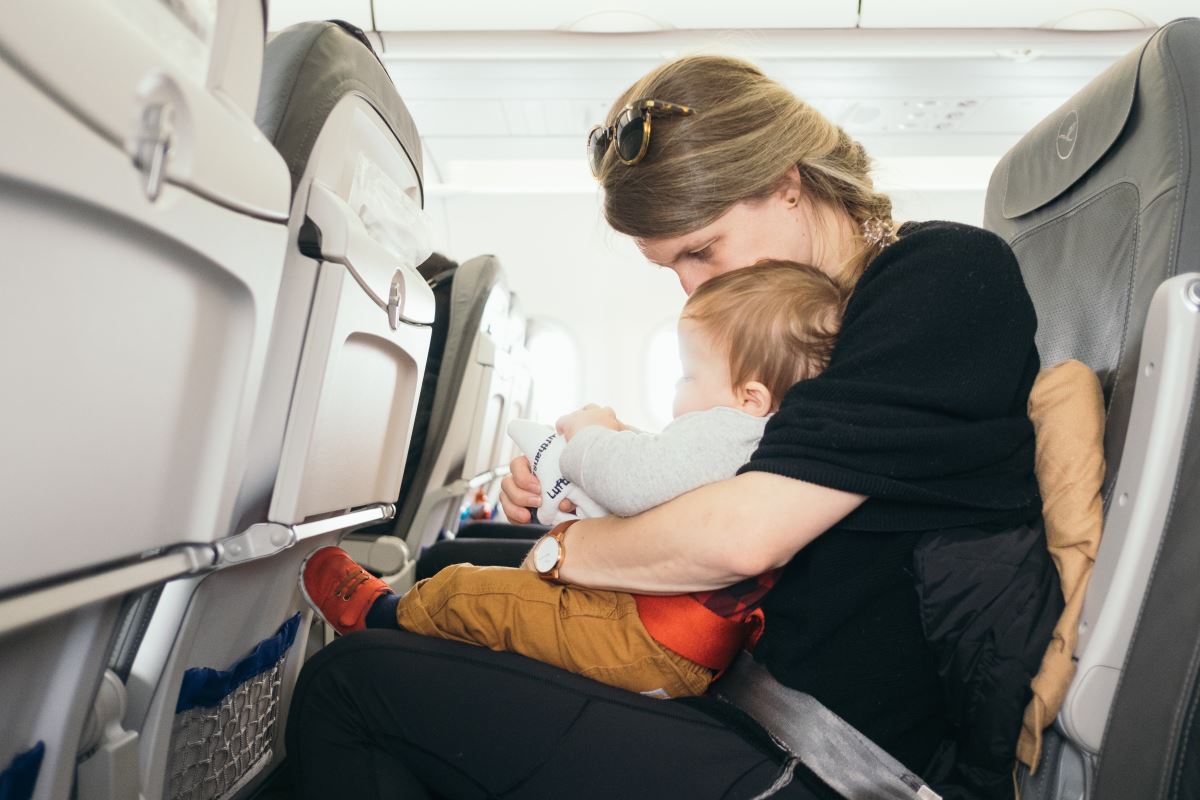 a woman holding a baby on an airplane