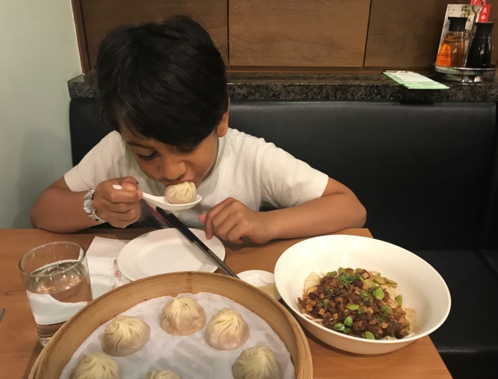 a boy eating food at a table
