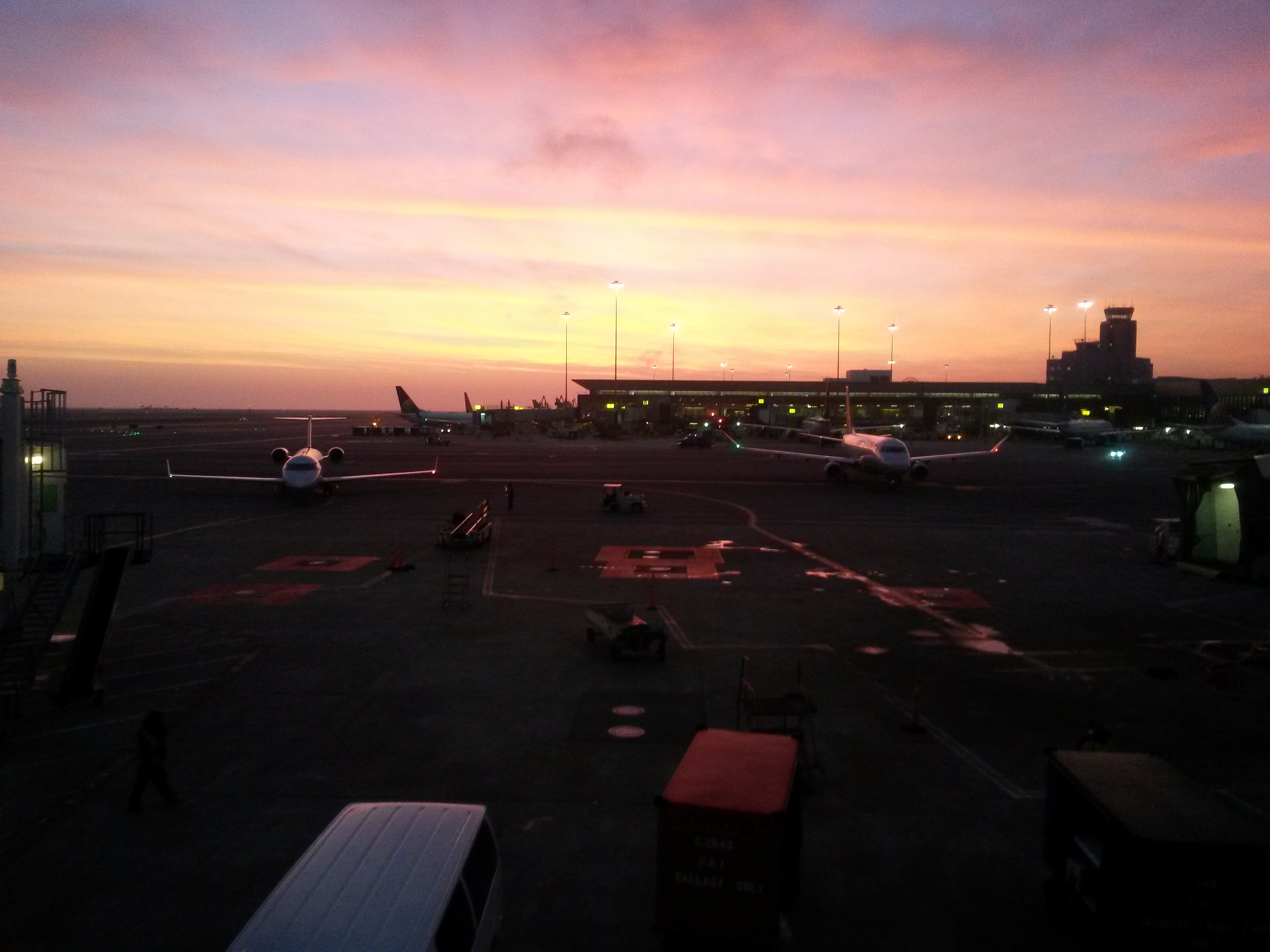 airplanes on a runway at sunset