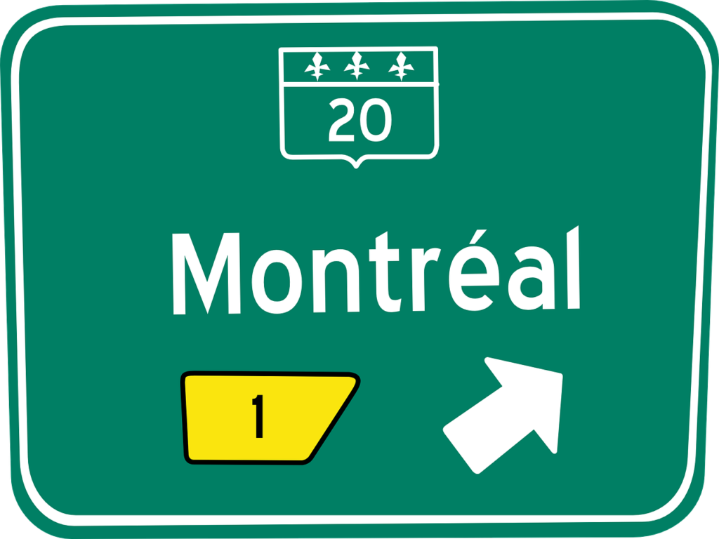a green sign with white text and a yellow arrow
