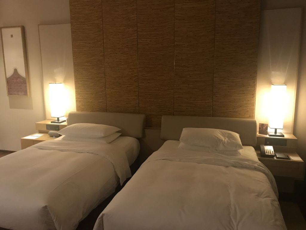 two beds with white sheets and pillows