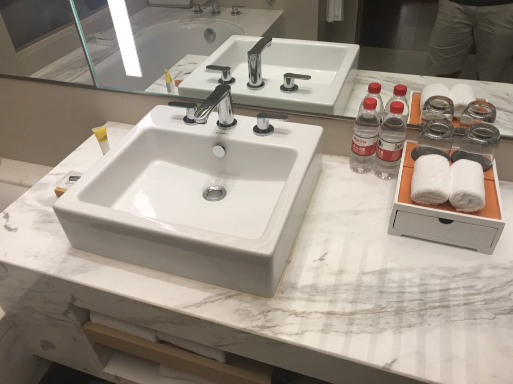 a bathroom sink with a mirror and a tray of water