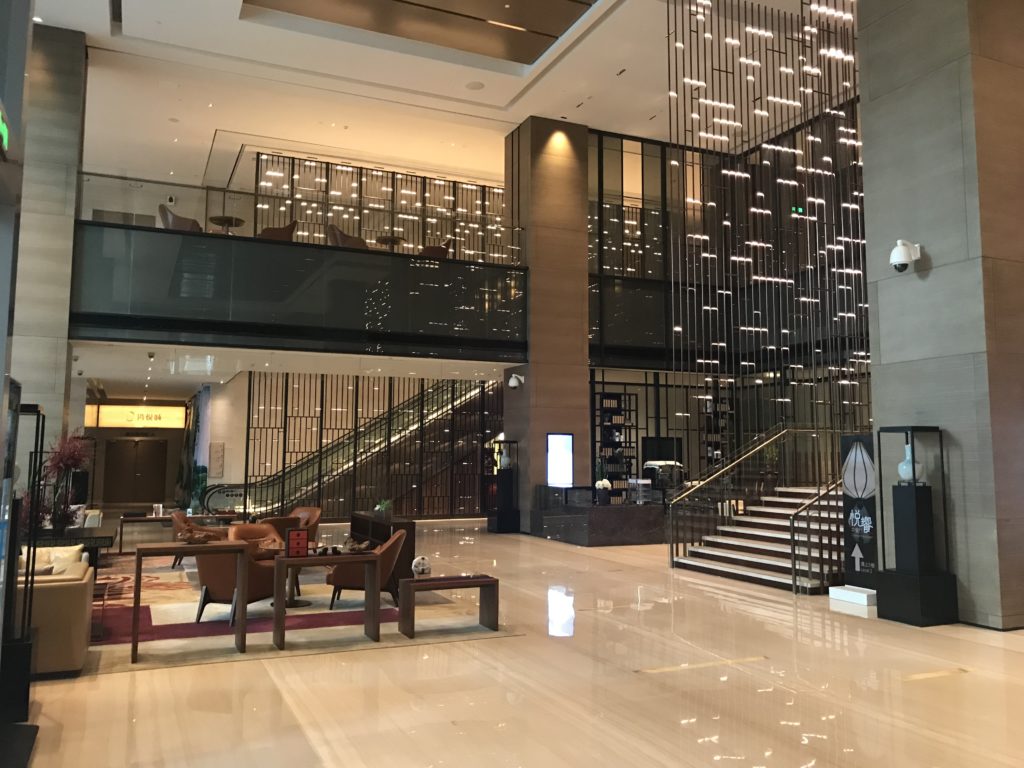 a large lobby with a staircase and a glass wall