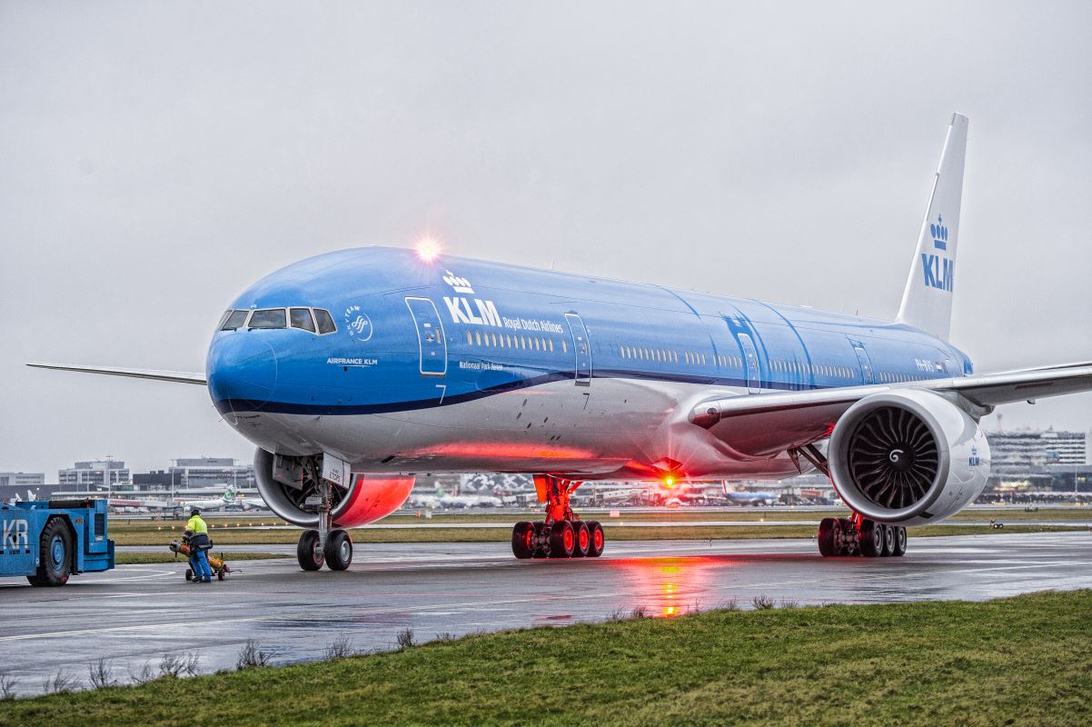 a blue and white airplane on a runway