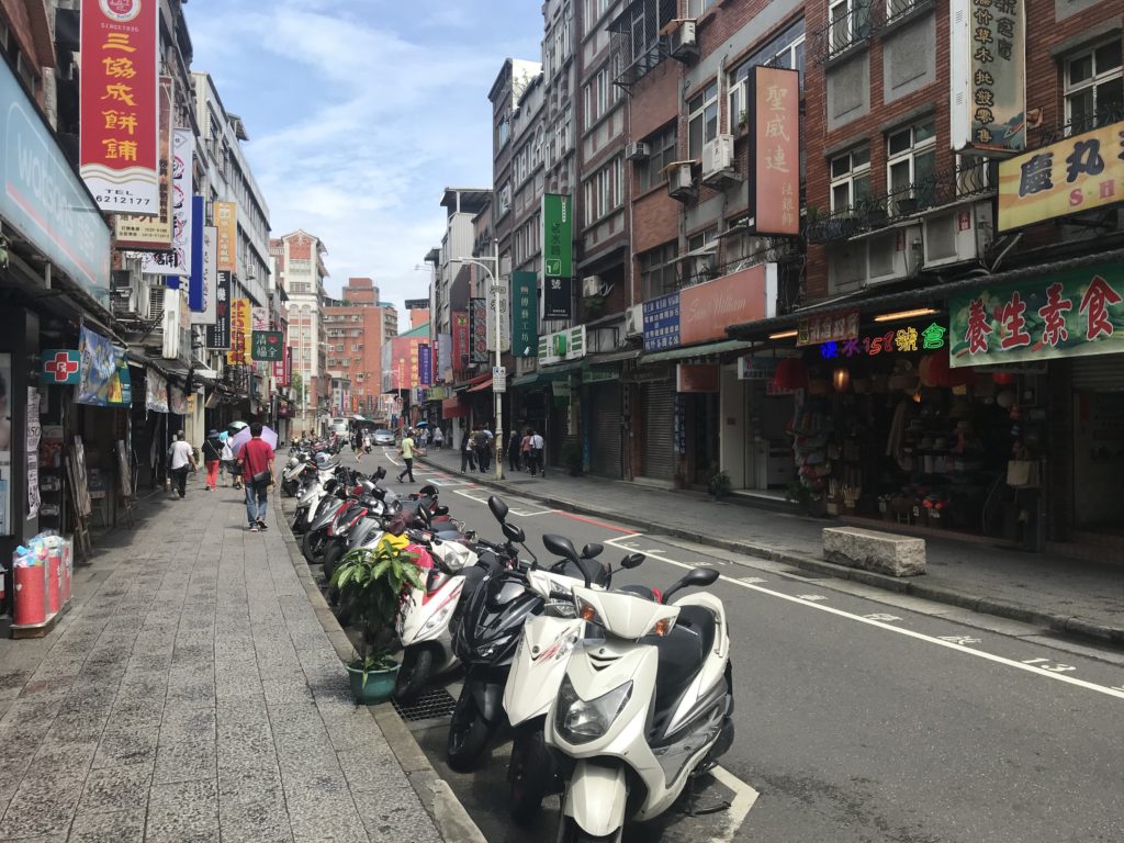 a row of scooters parked on a street