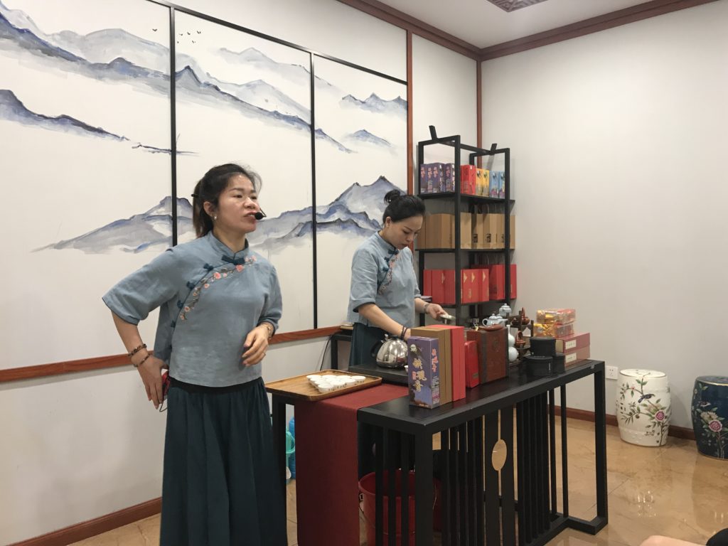 a woman in a room with a table with food and a painting on the wall