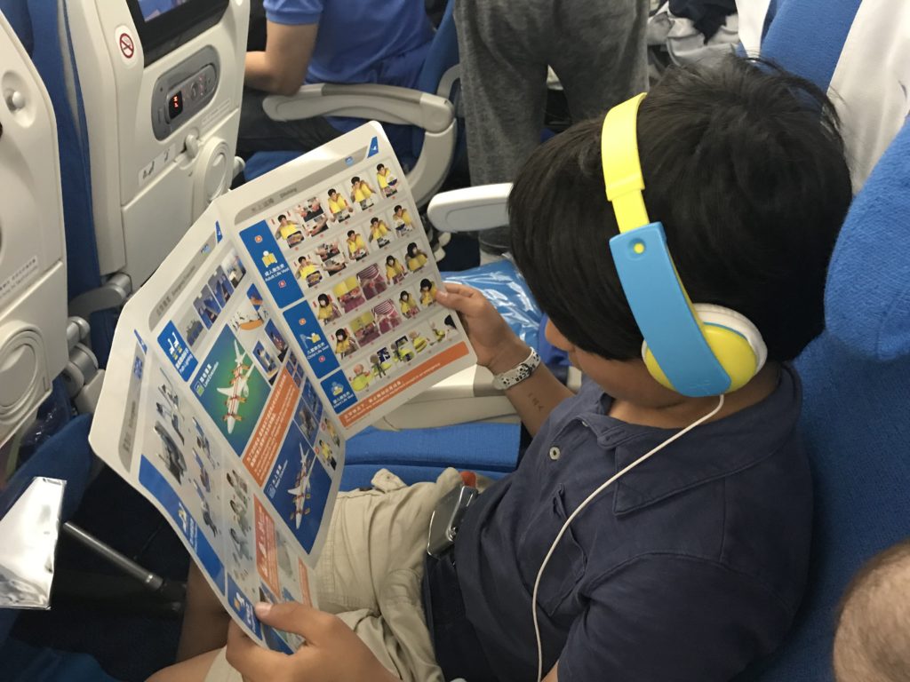 a boy wearing headphones and reading a book