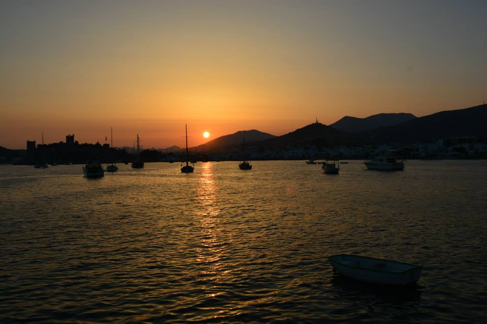 a sunset over a body of water with boats