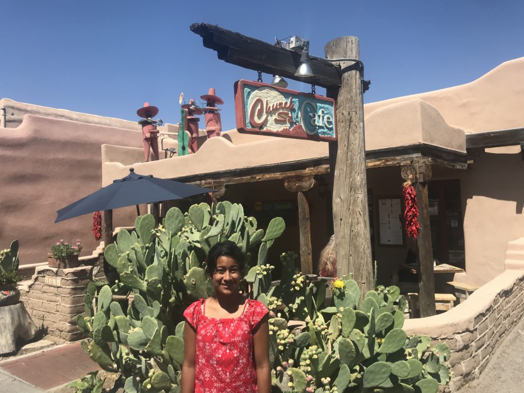 a girl standing in front of a cafe