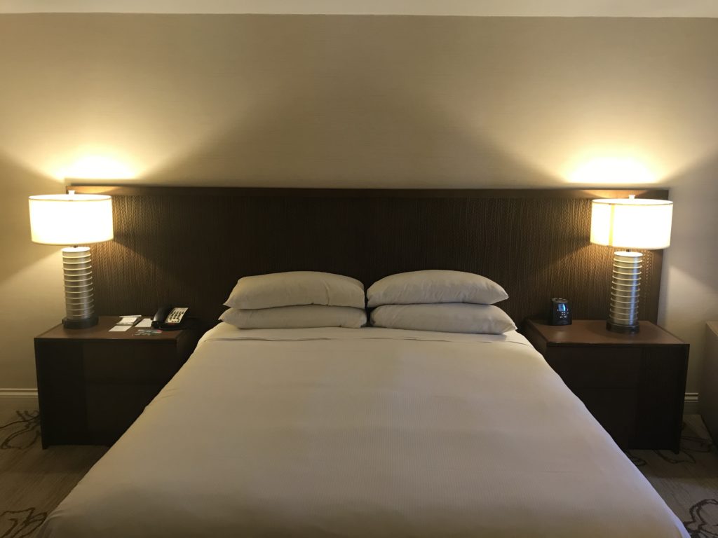 a bed with pillows and lamps