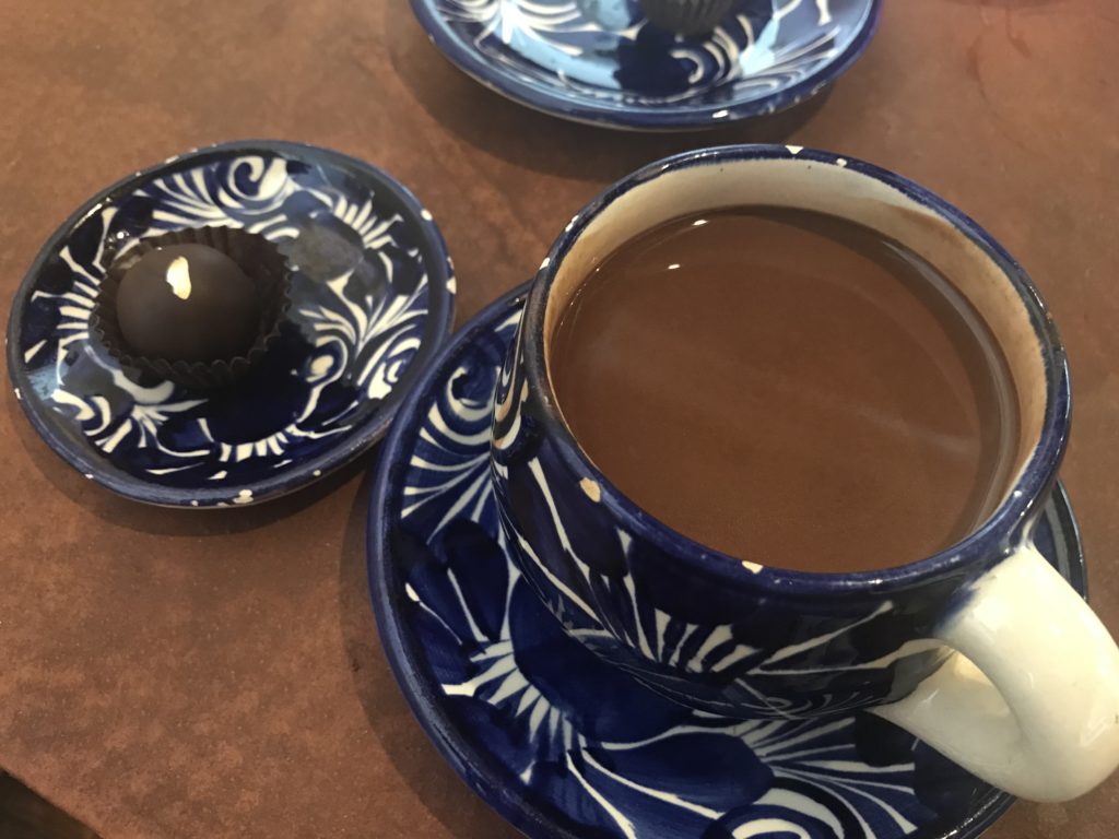 a cup of coffee and a chocolate candy on plates