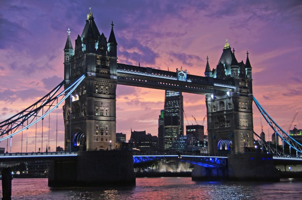 a bridge over water with a city in the background