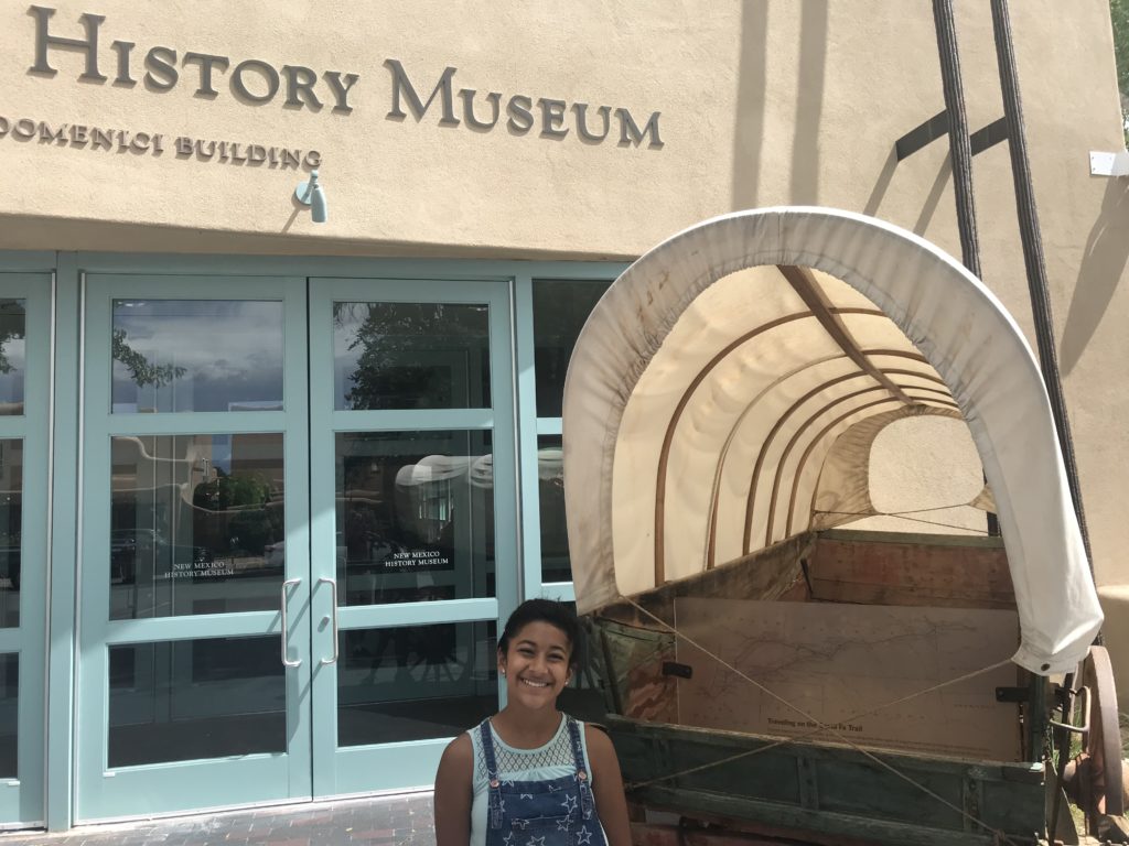 a girl standing in front of a museum