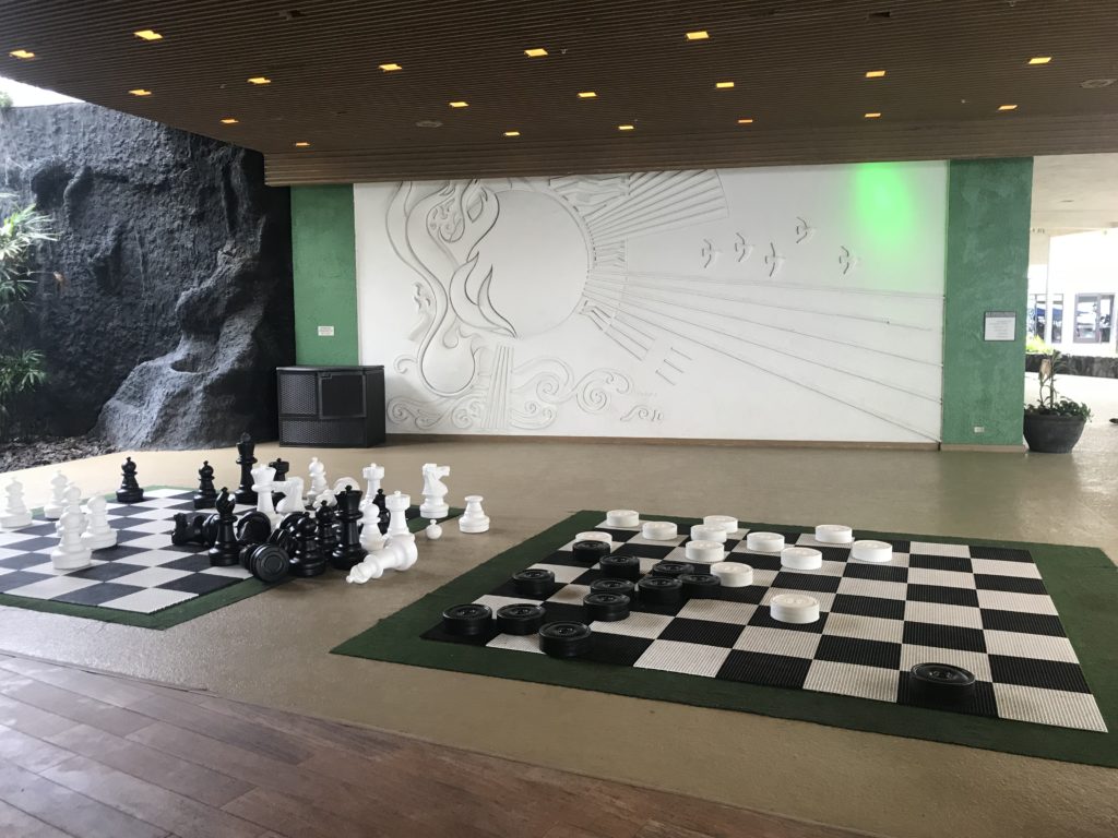 a large room with a large chess board and chess pieces