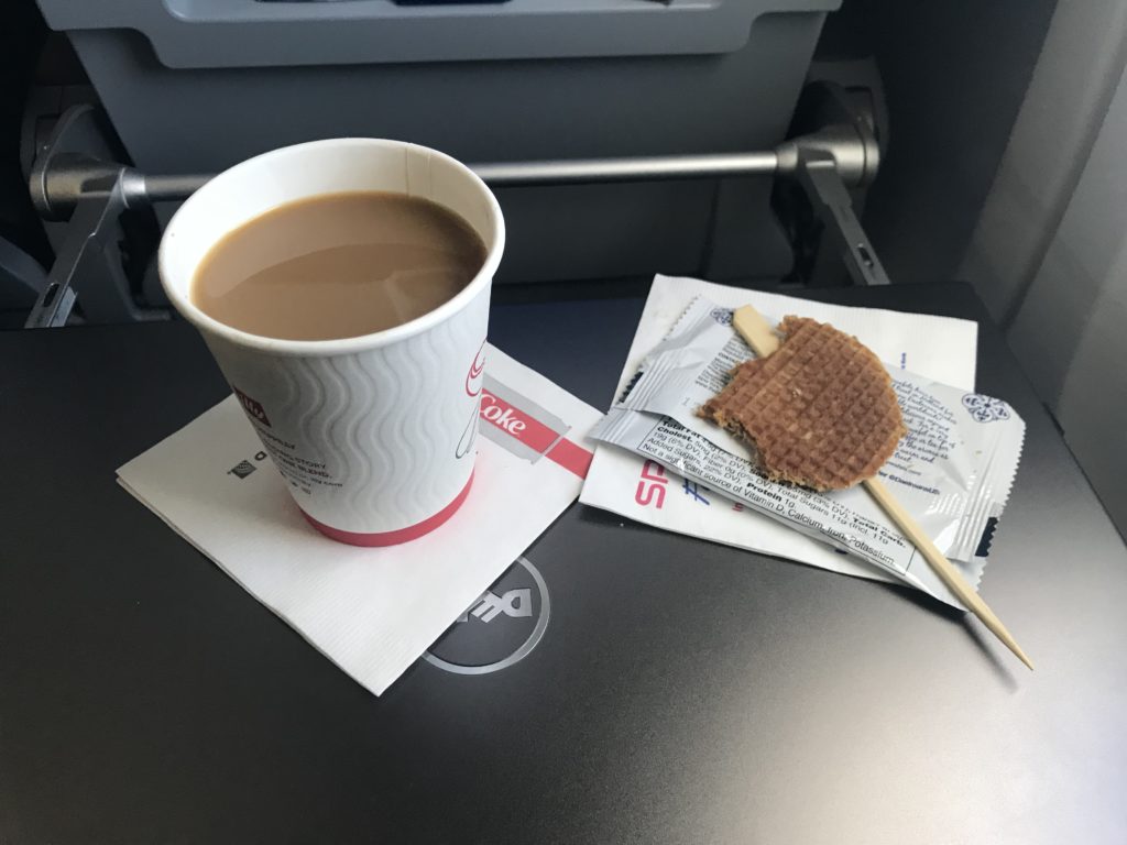 a cup of coffee and a waffle on a table