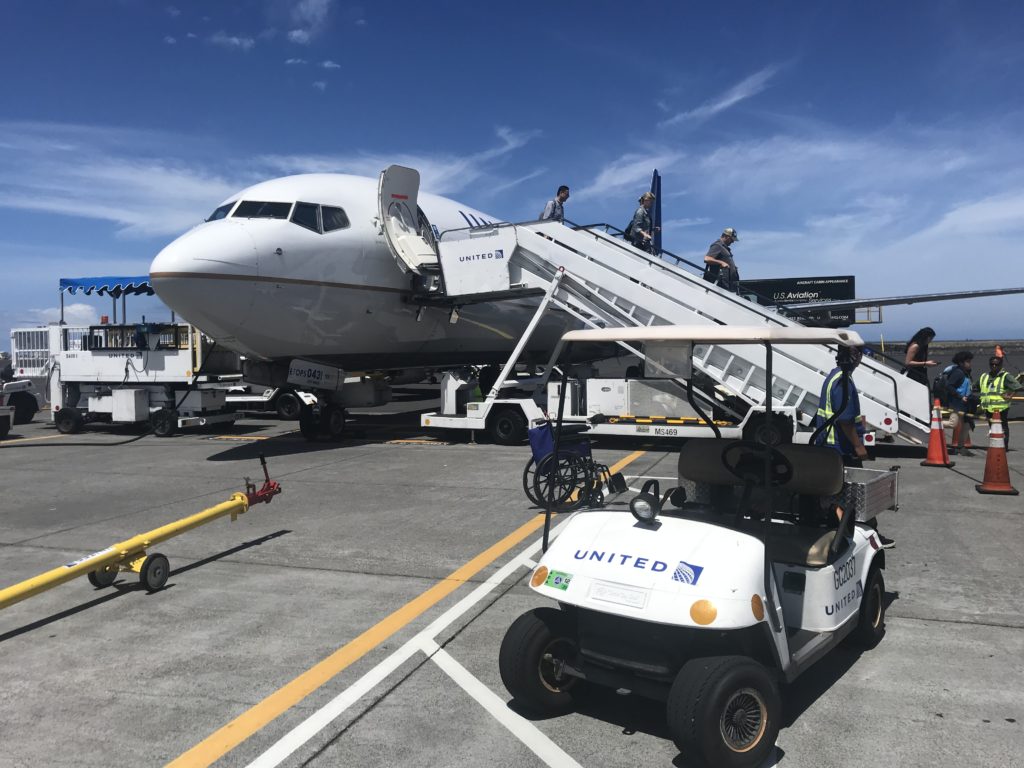 a white airplane with a golf cart and people on it