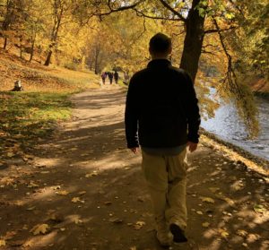 a man walking on a path by a river