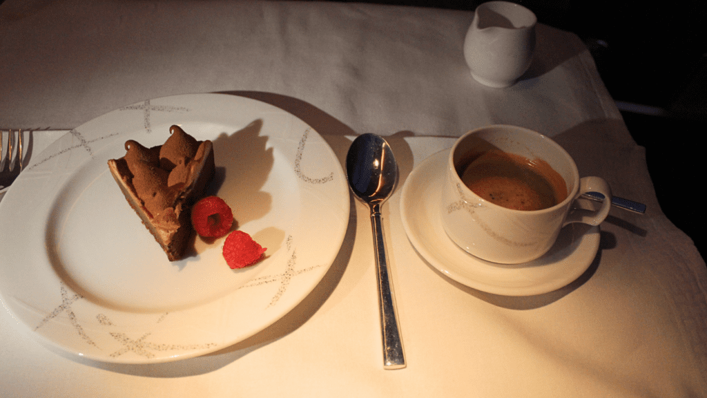 A plate of dessert and a cup of coffee on Cathay Pacific